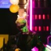 Stylish figure in cyberpunk sunglasses under vibrant neon lights, exuding futuristic vibes.